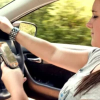 attempting-to-text-on-cell-phone-while-driving-car-725x482